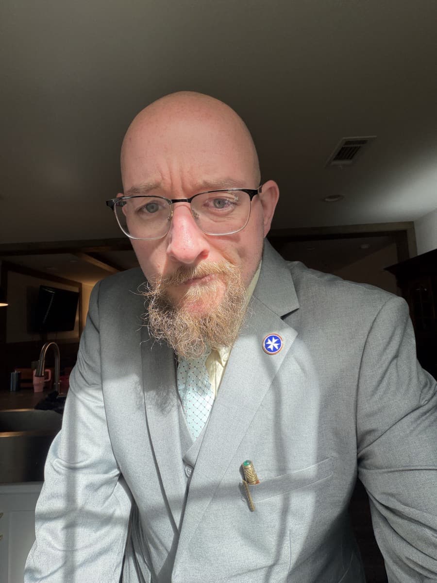 Kiefer Likens, Head of Design and Creative, wearing a grey three-piece suit.